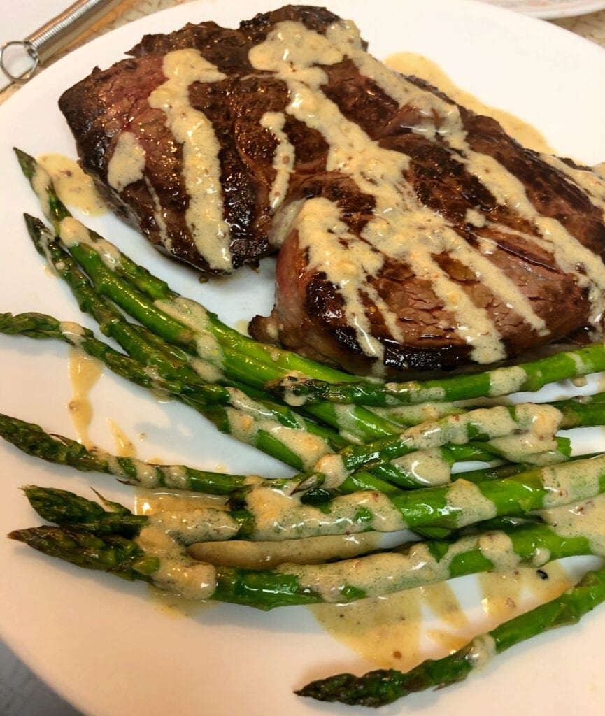 Rib Eye Steak Served with Asparagus and Creamy Garlic Butter Sauce