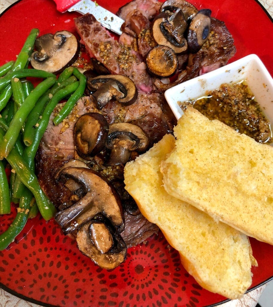 Green Beans, Steak, Fried Mushrooms, Mustard Butter Sauce, and Garlic Bread