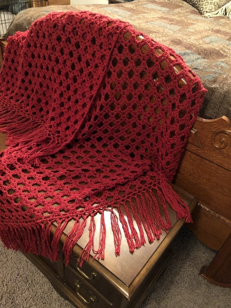 Sophisticated Scarlet Crochet Throw Displayed on the end of a Bed