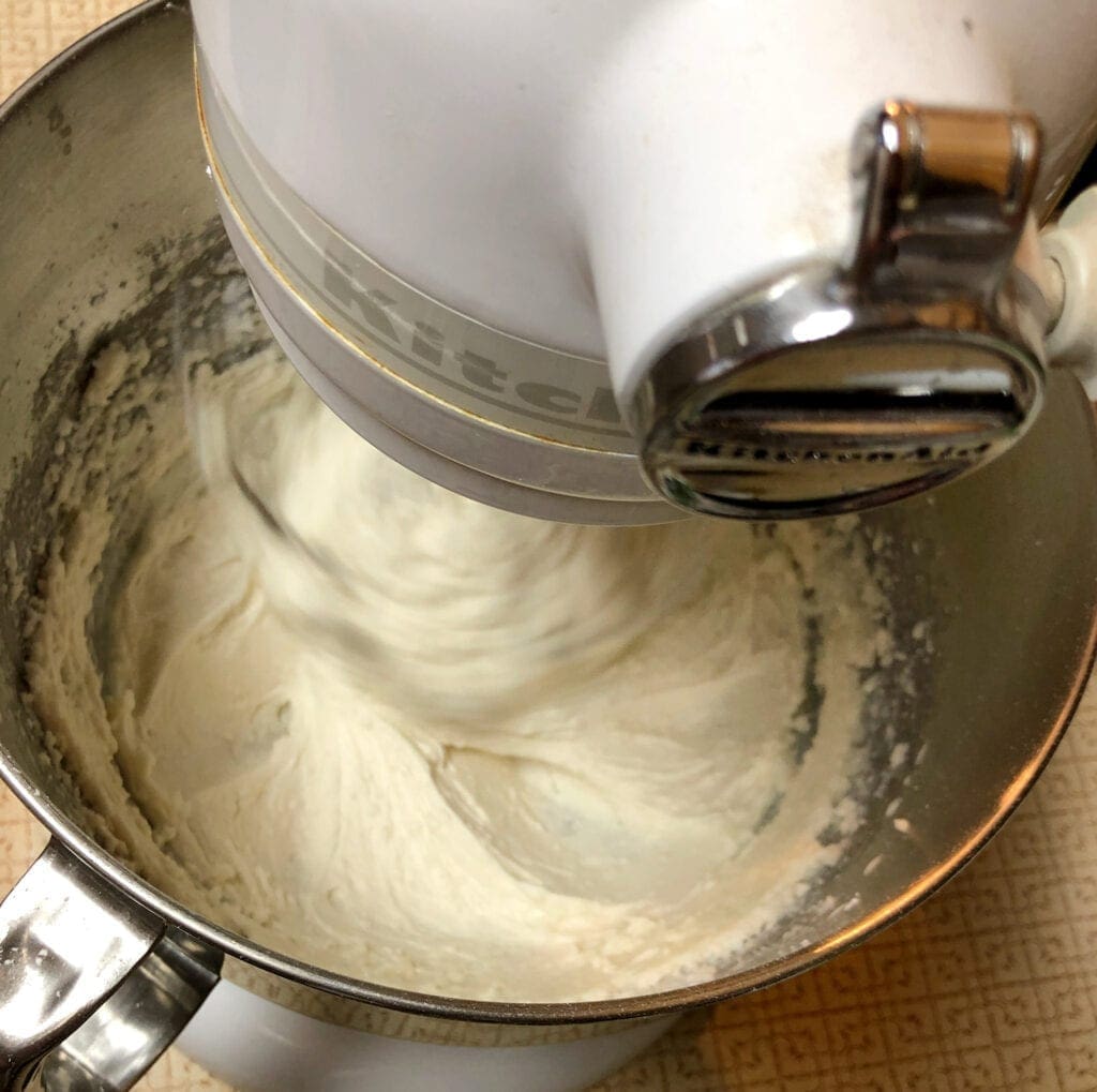 Mixing Butter Powdered Sugar Vanilla and Cream with Stand Mixer