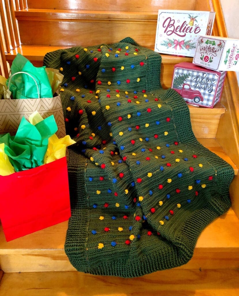 Festive Light Crochet Blanket on Steps with Holiday Boxes and Bags