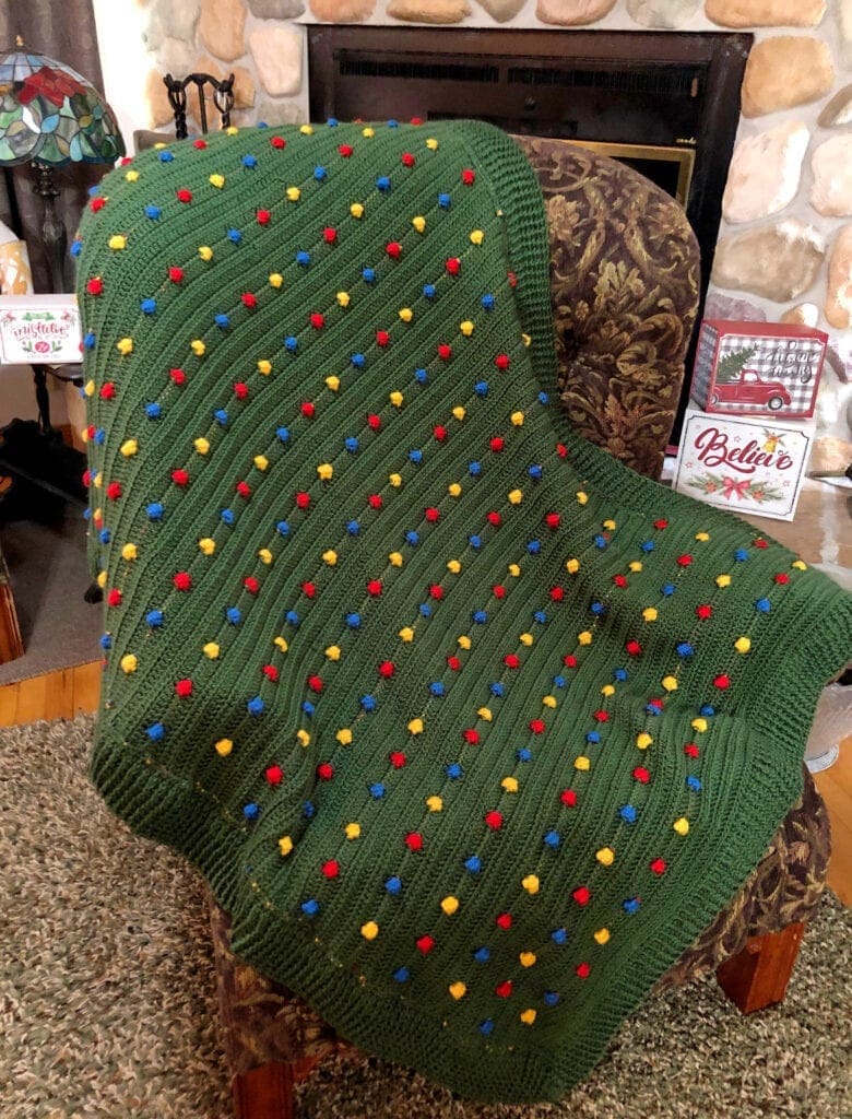 Crochet Christmas Blanket on a Chair in Front of Fireplace