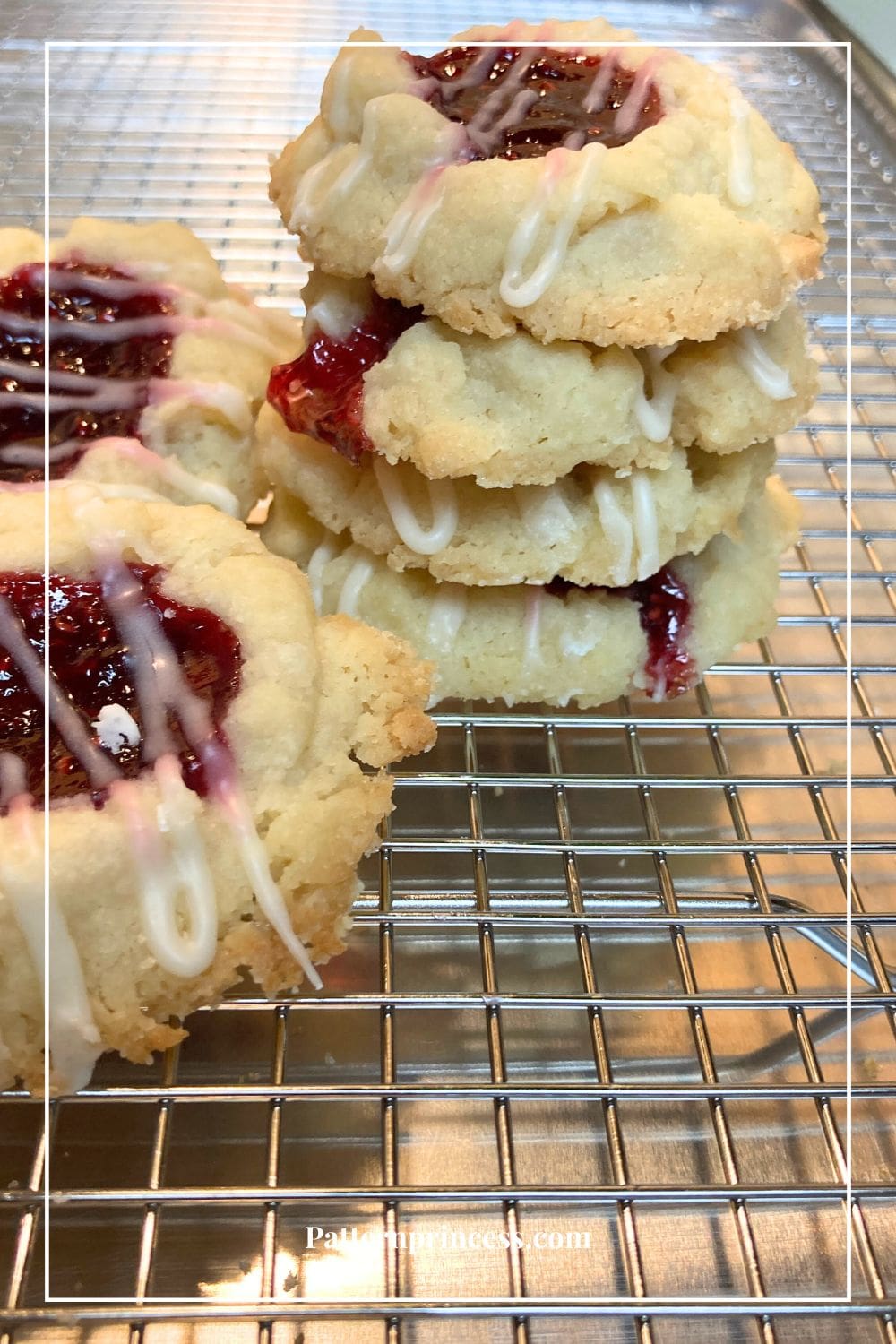 Raspberry Thumbprint Cookies Stacked on Wire Rack