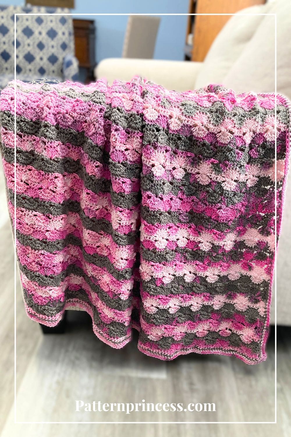 Pink and Grey Swirled Crochet Blanket Draped on Sofa